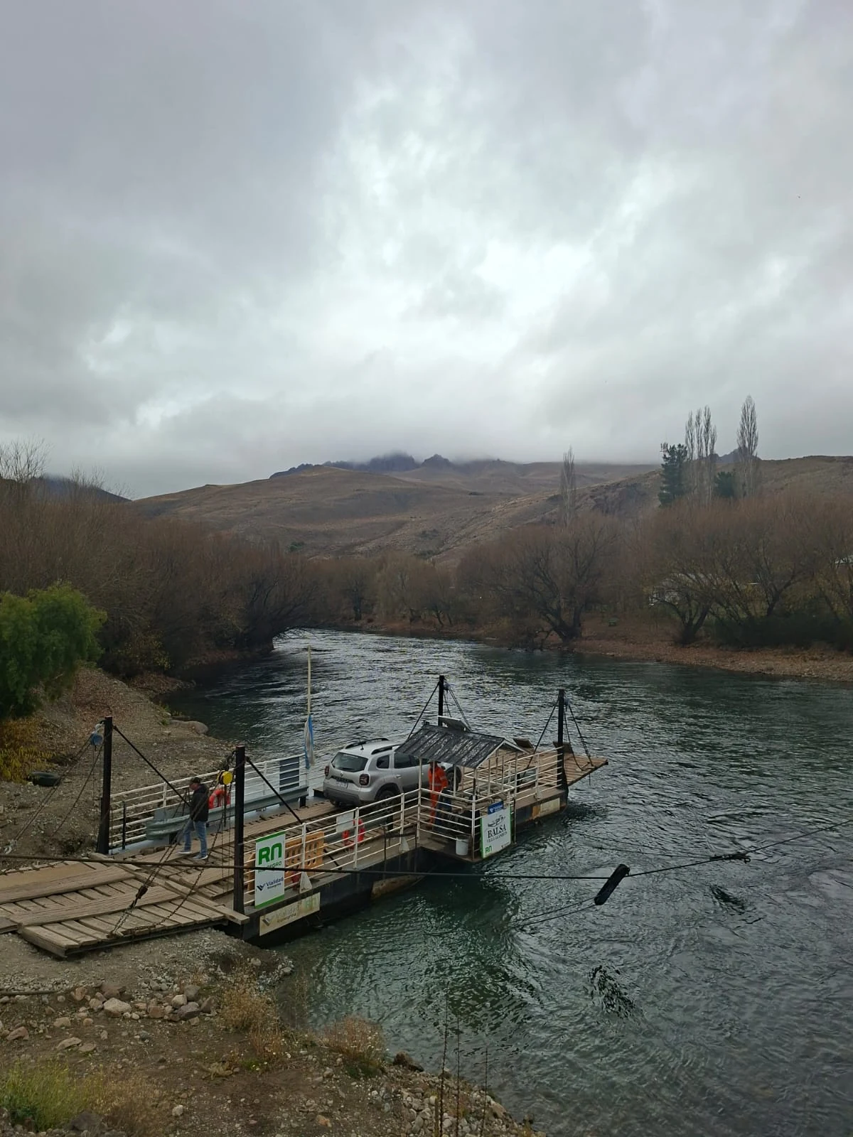 Balsa Maroma sobre el Río Limay en un día nublado